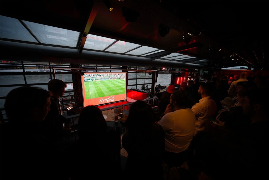 Invités regardant le match sur l'écran géant du Club Coca-Cola