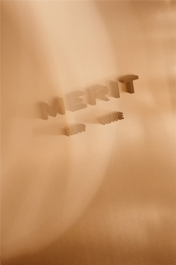Logo Merit en relief sur un mur aux tons dorés
