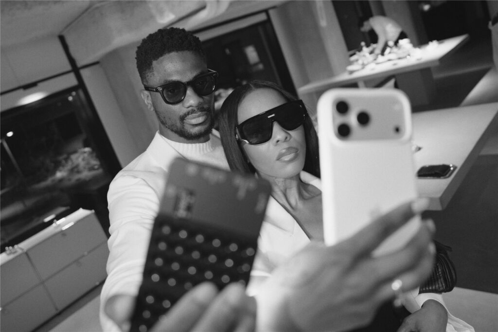 Deux invités en lunettes de soleil prenant un selfie, en noir et blanc