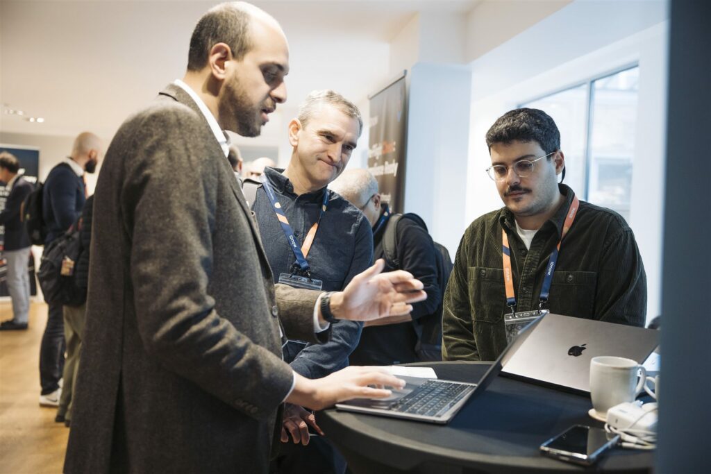 Échange autour d'un ordinateur portable entre participants pendant la pause networking