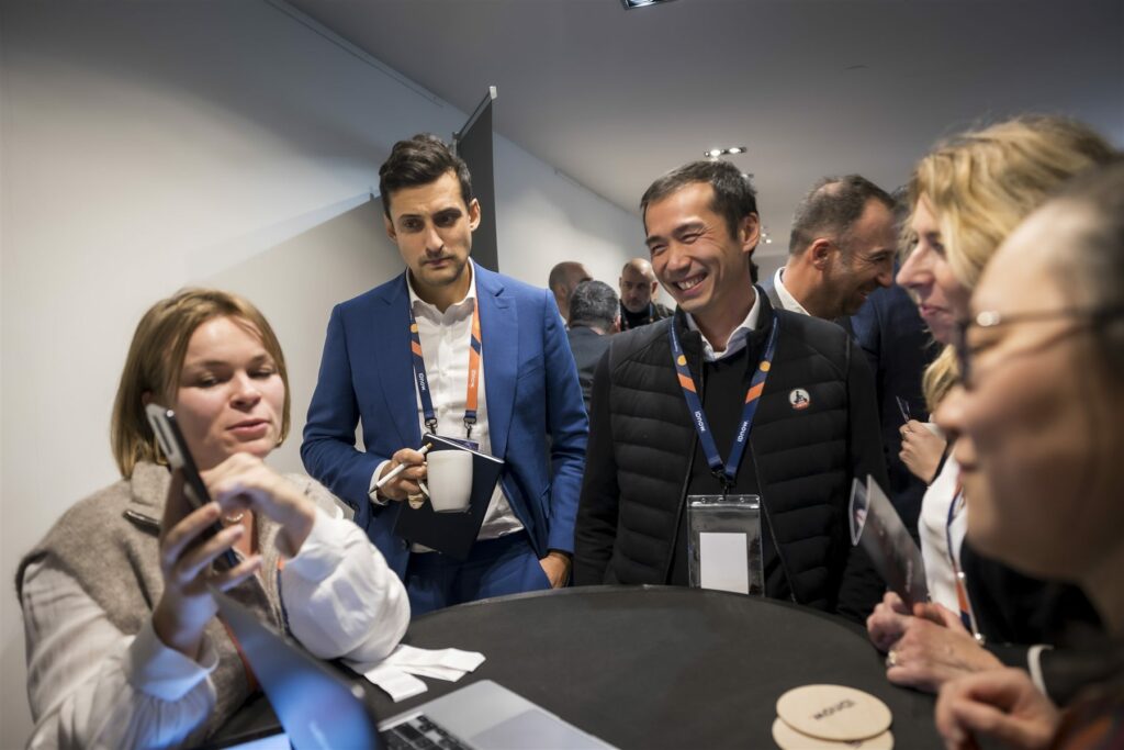 Participants discutant et riant autour d'un mange-debout pendant le networking