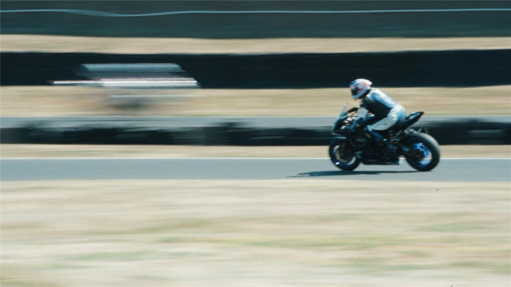 Moto noire en filé de vitesse sur la piste du Circuit Carole